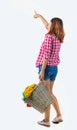 Back view of pointing woman with basket dirty laundry. girl is engaged in washing. Royalty Free Stock Photo