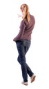 Back view of pointing woman. beautiful blonde girl in jeans Royalty Free Stock Photo