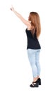 Back view of pointing woman. beautiful redhead girl in jeans. Royalty Free Stock Photo