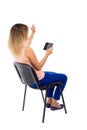 Back view of pointing woman sitting on chair and looks at the sc Royalty Free Stock Photo