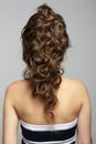 Back view portrait of beautiful young dark brunette woman on gray background Royalty Free Stock Photo