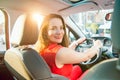 Back view Portrait of business lady, caucasian young woman driver looking at camera and smiling over her shoulder while driving a Royalty Free Stock Photo