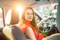 Back view Portrait of business lady, caucasian young woman driver looking at camera and smiling over her shoulder while driving a Royalty Free Stock Photo