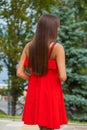 Young beautiful woman in red dress walking on the summer street Royalty Free Stock Photo