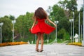 Young beautiful woman in red dress walking on the summer street Royalty Free Stock Photo