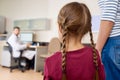 Scared Little Girl Entering Doctors Office with Mom Royalty Free Stock Photo