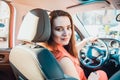 Back view Portrait of smiling business lady, caucasian young woman driver looking at camera and smiling over her shoulder while Royalty Free Stock Photo
