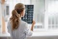 Doctor checking x-ray while standing in front of window Royalty Free Stock Photo