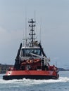 Back  view of a Powerful Tugboat moving fast next to breakwater to the ship to be towed Royalty Free Stock Photo