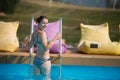 Back view pretty woman in swimwear is going out of the pool, turned around Royalty Free Stock Photo