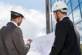 Back view of professional architects in hardhats working