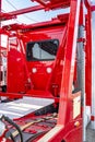 Back view of red big rig semi truck tractor with hydraulic modular two level semi trailer standing on the warehouse parking lot at Royalty Free Stock Photo