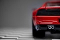 Back view of a Red toy Ferrari 348TB sports car close up product shot on a chequered ground and gray background Royalty Free Stock Photo