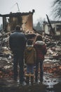 back view of refugee family looking at destroyed home after war, desperate people near demolished house after natural Royalty Free Stock Photo