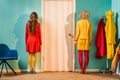 back view of retro styled women standing at door at colorful apartment doll