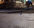 Process of leveling the asphalt manually using a special rake.