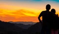 Back view of romantic couple watching beautiful sunset over mountain layer. Couple travel. Backpacker happy in love and travelling Royalty Free Stock Photo