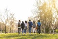 Back view of a row of young multi-ethnic students walking together in the park Royalty Free Stock Photo