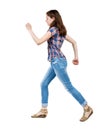 Back view of running woman in jeans Royalty Free Stock Photo