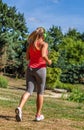 Back view of 20s blond woman jogging with headphones Royalty Free Stock Photo