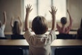 Back view of schoolboy raising hands in classroom. Back view of schoolboy raising hands in classroom. Little students full rear