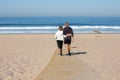 Back view of senior couple having active rest on sandy beach Royalty Free Stock Photo