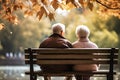 Back view of senior couple sitting on bench in the park