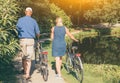 Back view of senior couple walking with bicycles in the park at sunset Royalty Free Stock Photo