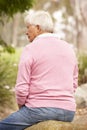 Back View Of Senior Man Sitting On Wall Royalty Free Stock Photo