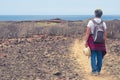 Back view of senior woman with backpack in outdoor trekking, looking at horizon over sea Royalty Free Stock Photo
