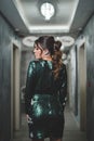 Back view of a sexy Bosnian brunette girl in stylish green sequins dress posing in the corridor