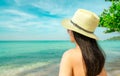 Back view of young Asian woman wear pink bikini, straw hat, and sunglasses relaxing and enjoy holiday at tropical paradise Royalty Free Stock Photo