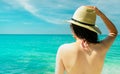 Back view of young Asian woman wear pink bikini, straw hat, and sunglasses relaxing and enjoy holiday at tropical paradise Royalty Free Stock Photo