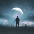 Back view of a silhouette of a person walking alone under the night sky Royalty Free Stock Photo