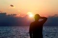 Back view silhouette photo of depressed man watching the sunset on the sea. Royalty Free Stock Photo