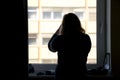 Back view of silhouette of a woman putting on makeup in front of Royalty Free Stock Photo