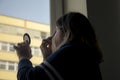 Back view of silhouette of a woman putting on makeup in front of Royalty Free Stock Photo