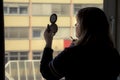 Back view of silhouette of a woman putting on makeup in front of Royalty Free Stock Photo