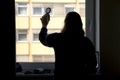 Back view of silhouette of a woman putting on makeup in front of Royalty Free Stock Photo