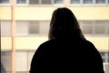 Back view of silhouette of a woman putting on makeup in front of Royalty Free Stock Photo