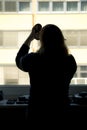 Back view of silhouette of a woman putting on makeup in front of Royalty Free Stock Photo