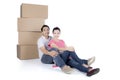 Back view of sitting cute couple with stack of cardboard boxes Royalty Free Stock Photo