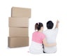 Back view of sitting cute couple with stack of cardboard boxes