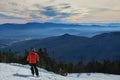 Back view of the skier in red jacket riding down the slope in Stowe mountains. Winter sport. Royalty Free Stock Photo