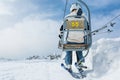 Back view of skier riding a lift.