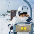 Back view of skier riding a lift.