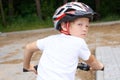 Back view of small boy in protective helmet riding bicycle in park on summer day. Weekend activity. Royalty Free Stock Photo