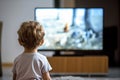 Back view of small child watching TV