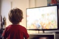 Back view of small child watching TV