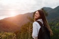 Back view of smiling girl with backpack in mountains Royalty Free Stock Photo